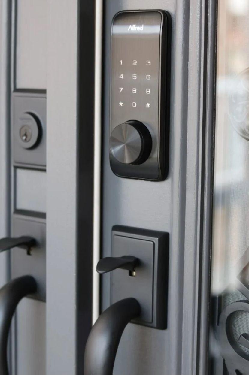 Matte black keypad smart deadbolt installed above a matching handleset