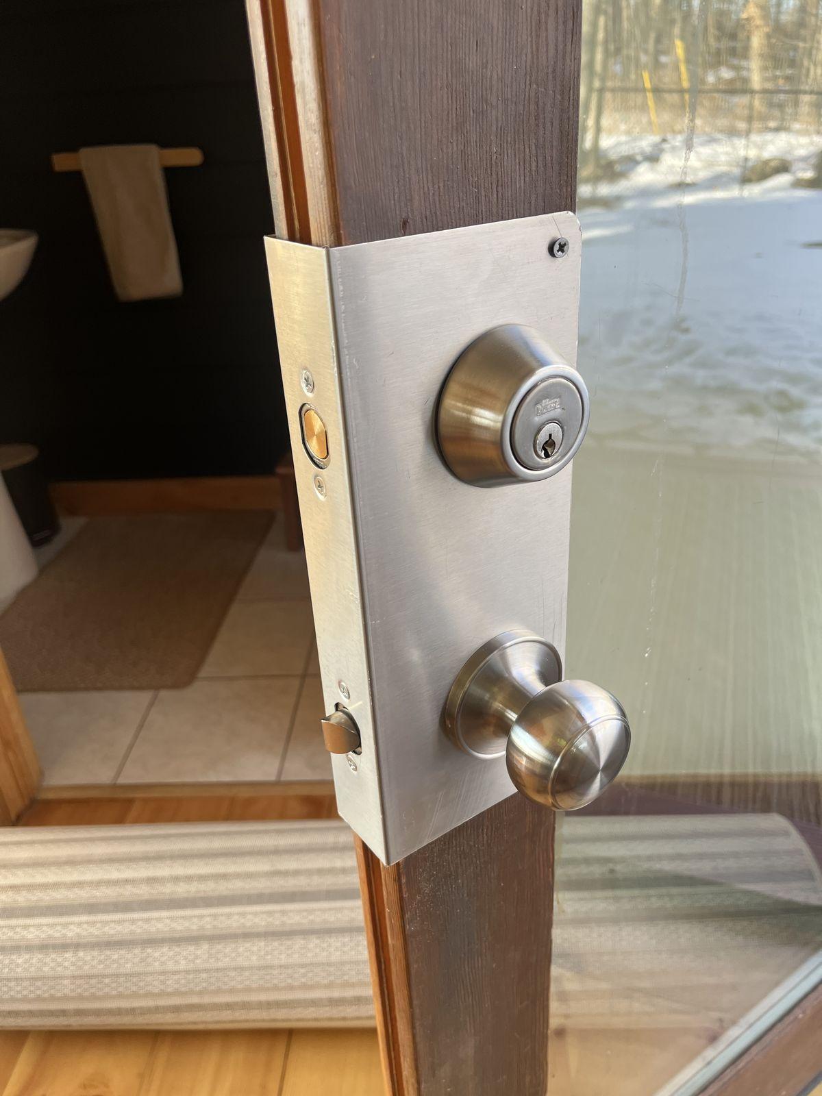 Brushed nickel deadbolt and knob handleset installed on a residential door