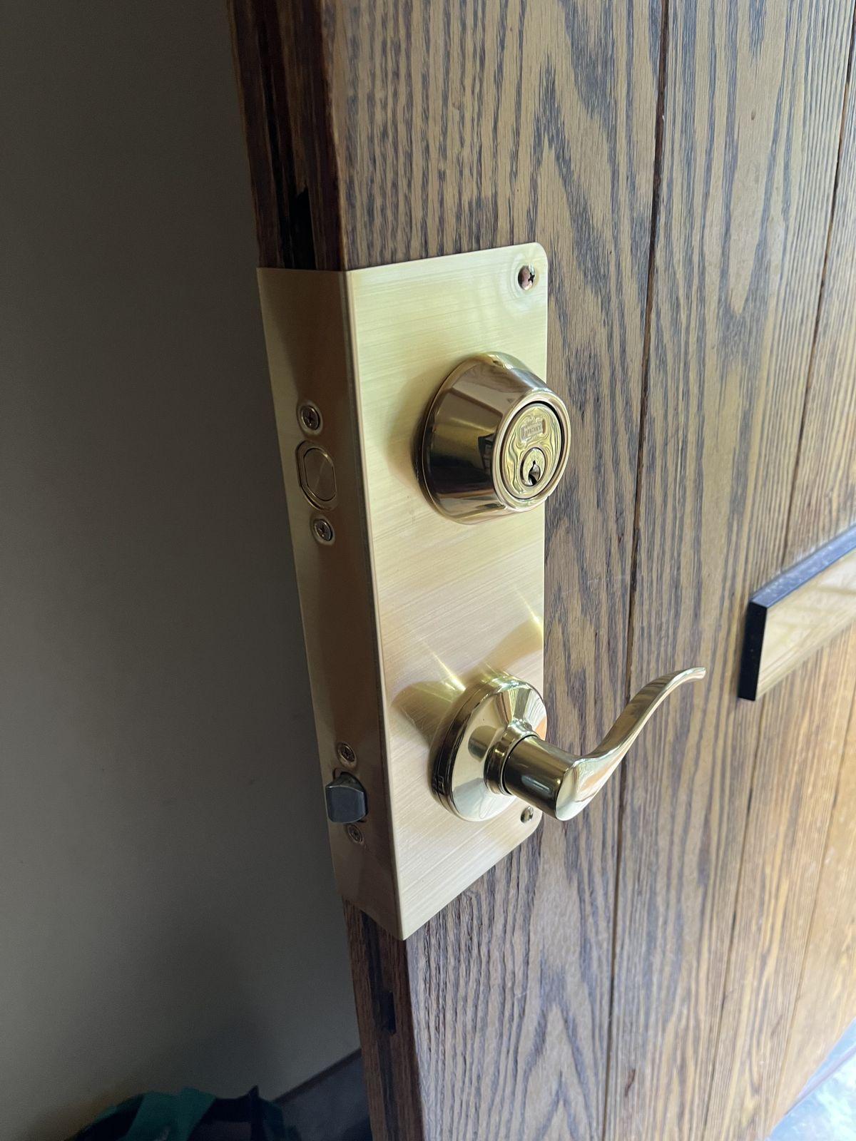 Brass deadbolt and lever handleset installed on a residential front door