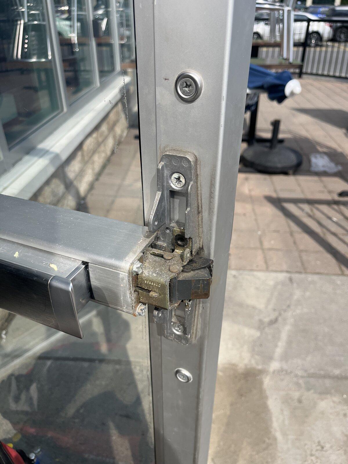 Storefront exit-device latch and strike during panic bar repair in Kanata