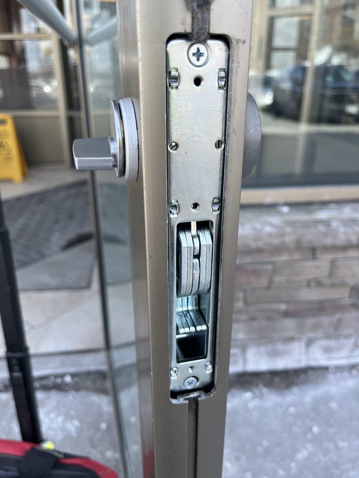 High-security commercial lock cylinder installed on a storefront door